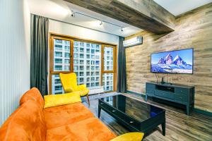 Una sala de estar con un sofá y un televisor. en Park Azure One Bedroom Luxury Apartment, en Baku