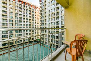 un balcón con 2 sillas y una mesa y algunos edificios en Park Azure One Bedroom Luxury Apartment, en Baku