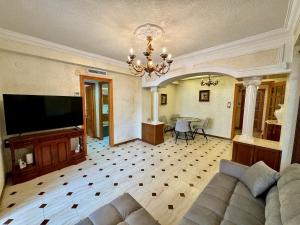 een woonkamer met een bank en een flatscreen-tv bij Wagner Playa Apartment in Cullera