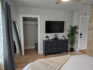 a living room with a tv and a black dresser at Stylish Modern Studio in Vibrant Walker's Point in Milwaukee