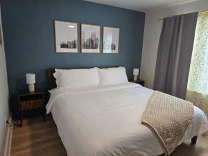 a bedroom with a large white bed with blue walls at Stylish Modern Studio in Vibrant Walker's Point in Milwaukee