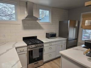 a kitchen with a stove and a refrigerator at Stylish Modern Studio in Vibrant Walker's Point in Milwaukee