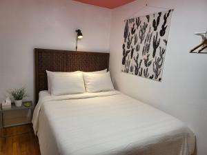 a bedroom with a bed with white sheets at Whole House in Walker's Point in Milwaukee