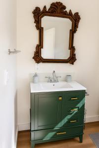 a bathroom with a green vanity and a mirror at Charming Casita near USC, SOFI, and Culver City in Los Angeles