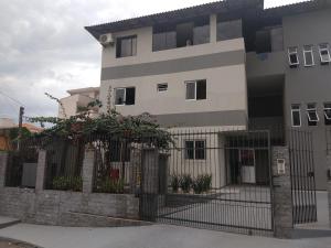 a building with a fence in front of it at Murilo House - Apart-hotel completo e privativo in São José