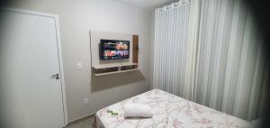 a bedroom with a bed and a tv on a wall at Murilo House - Apart-hotel completo e privativo in São José