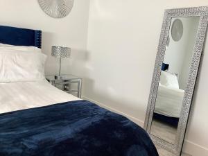 a bedroom with a bed and a mirror on the wall at Sapphire Lux Queen Suite in Kamloops