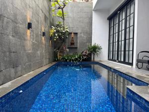 a swimming pool in a house with blue water at Atmadeva Boutique Villas in Batu