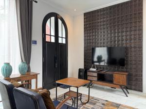 a living room with a flat screen tv on a wall at Atmadeva Boutique Villas in Batu