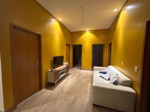 a living room with a white couch and a television at Hotel Araguaia Exclusive in Aruanã