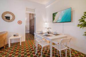 a dining room with a white table and chairs at Beachwalk San Juan by PH in San Juan