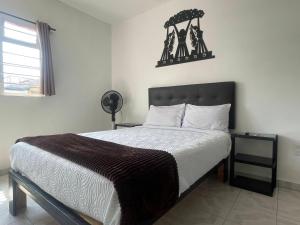 a bedroom with a large bed with a brown blanket at Alojamiento en Morelia in Morelia