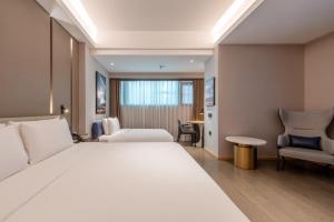 a hotel room with a large white bed and chairs at Atour Hotel Shenzhen Luohu Vientiane City in Shenzhen +84 photos