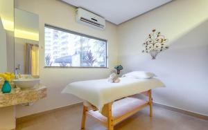 a bathroom with a bed and a sink and a window at Wyndhan Royal Hotel Resort Olimpia in Olímpia +20 photos