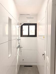 a white bathroom with a shower and a window at Cozy Duafe Villa 3BR 24hr Security WiFi East Legon in Ogbojo +54 photos