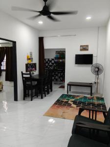 a living room with a ceiling fan and a table at Homestay Masjid Seberang Marang in Marang