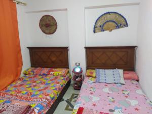 マルサ・マトルーフにあるTown House in Andalusia Villageのベッドが2つあり、壁に時計がある寝室