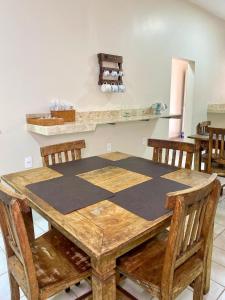 a wooden table with wooden chairs and a counter at Ipê Dourado Hotel in Natividade