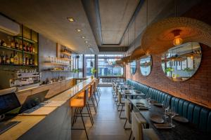 a restaurant with a long bar with tables and chairs at Cbmona Suites in Villa Mercedes