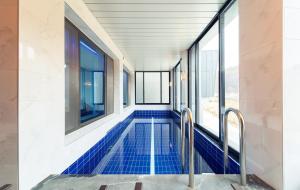 a swimming pool in a building with blue tiles at NJ Pool Villa in Hoengseong