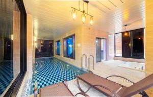 a pool in a house with chairs and a table at NJ Pool Villa in Hoengseong