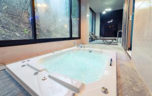 a jacuzzi tub in a room with a large window at NJ Pool Villa in Hoengseong
