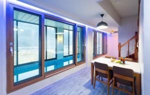 a dining room with a table and some windows at NJ Pool Villa in Hoengseong +11 photos