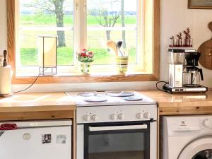a kitchen with a stove and a window at 2 person holiday home in ÖDESHÖG in Ödeshög