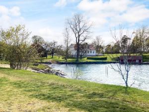 a house on a hill next to a river at 2 person holiday home in ÖDESHÖG in Ödeshög