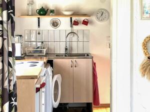 a small kitchen with a sink and a washing machine at 2 person holiday home in ÖDESHÖG in Ödeshög +15 photos