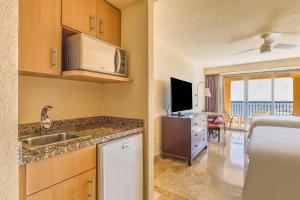 a kitchen with a sink and a television in a room at Grand Fiesta Americana Los Cabos All Inclusive Golf & Spa in Cabo San Lucas +258 photos