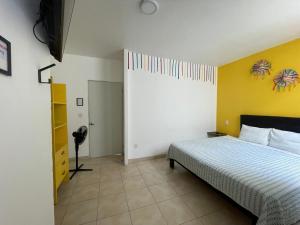Un dormitorio con una cama y una pared amarilla. en Aldama, en Morelia 4 fotos más