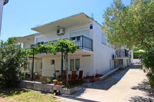 una casa bianca con un balcone sul lato di Apartments Neven - One Bedroom Apartment with Terrace and Garden View A2 a Drače