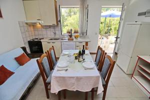 a kitchen with a table and chairs and a kitchen with a dining room at Apartments Neven - Studio Apartment with Terrace and Partial Sea View A3 in Drače
