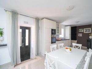 a kitchen and dining room with a white table and chairs at Holiday Home Majkovi - Three Bedroom Holiday Home with Swimming Pool in Slano +6 photos