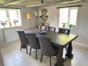 a dining room with a wooden table and chairs at 4 person holiday home in ESLÖV in Eslöv +17 photos