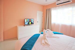 a bedroom with a bed with a tv on it at Blue Wave Samui in Bophut  +46 photos