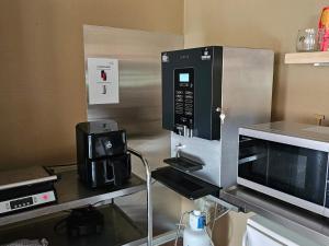 a kitchen with a microwave and a coffee maker at Cozy Danish Room for Solo Stays in Lemvig +25 photos