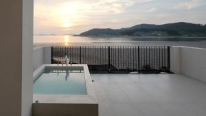a balcony with a swimming pool and a view of the water at Taean Maru Private Pool Villa in Taean
