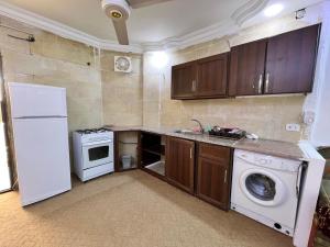 a kitchen with a washing machine and a washer at فندق المفرق غرف فندقيه وشقق مخدومه in Al Mafraq