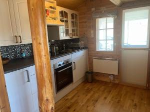 a kitchen with white cabinets and a wooden floor at 4 star holiday home in KIL in Kil +29 photos