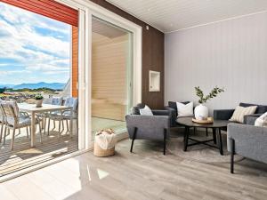 a living room with a balcony with a table and chairs at 8 person holiday home in Sandøy in Finnøy