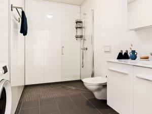 a white bathroom with a toilet and a shower at 8 person holiday home in Sandøy in Finnøy +25 photos