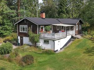 a small house with a porch on top of a yard at 8 person holiday home in Ärla in Malmköping