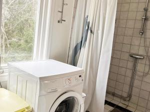 a washing machine in a bathroom with a shower at 5 person holiday home in INGARÖ 