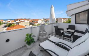 a balcony with two chairs and an umbrella at 2 Bedroom Beautiful Apartment In Vodice in Vodice