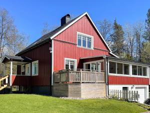a red house with a porch and a balcony at Cozy 2-Bedroom Apartment in the Alps in Vasared