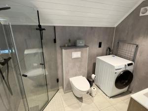 a bathroom with a toilet and a glass shower at 4 star holiday home in Huglo in Nordhuglo +35 photos