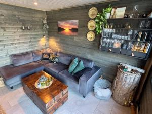 a living room with a leather couch and a table at 4 star holiday home in Huglo in Nordhuglo