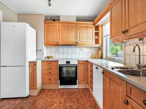 a kitchen with wooden cabinets and a white refrigerator at 8 person holiday home in Stavang in Stavang